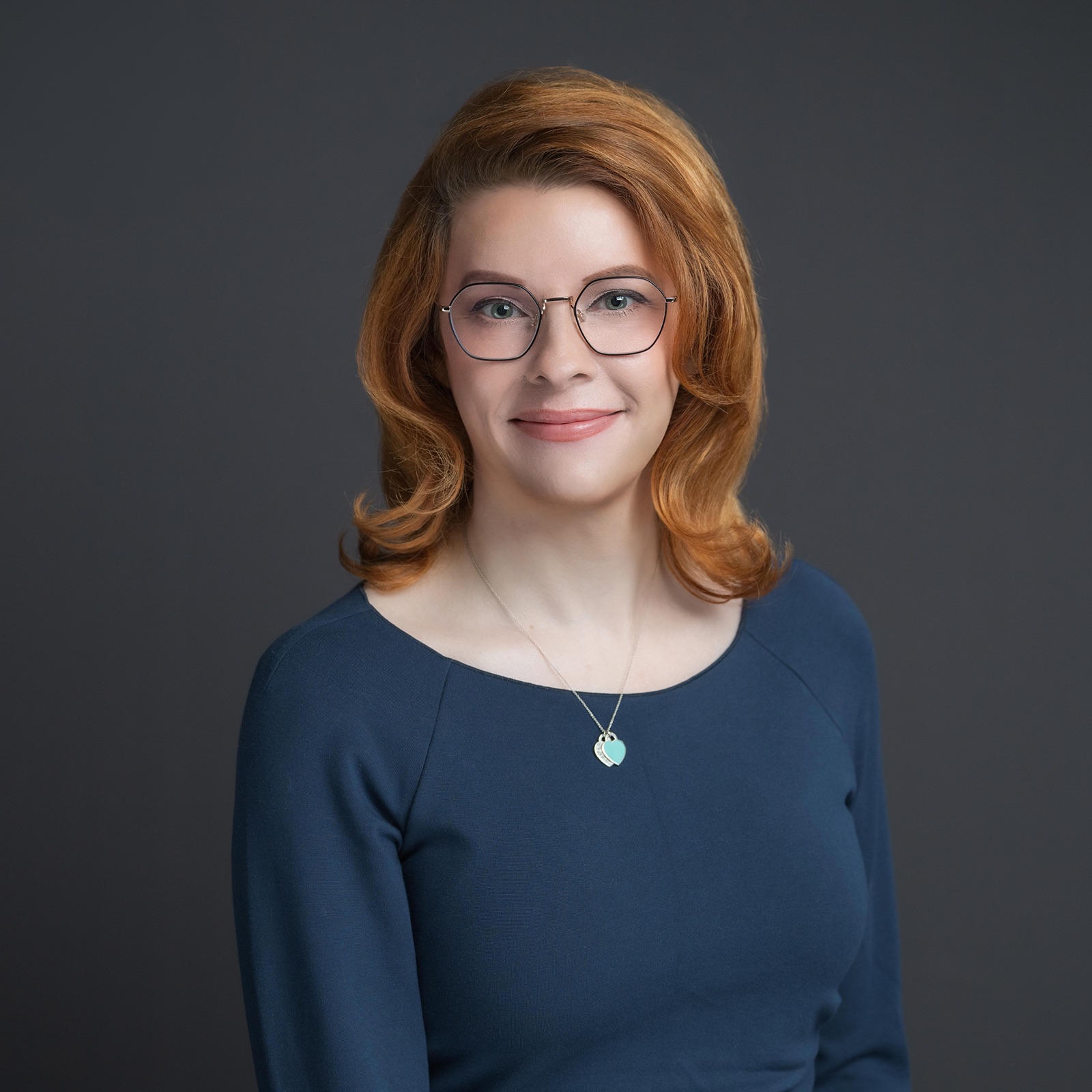 Danni Askini in navy blouse, warm expression